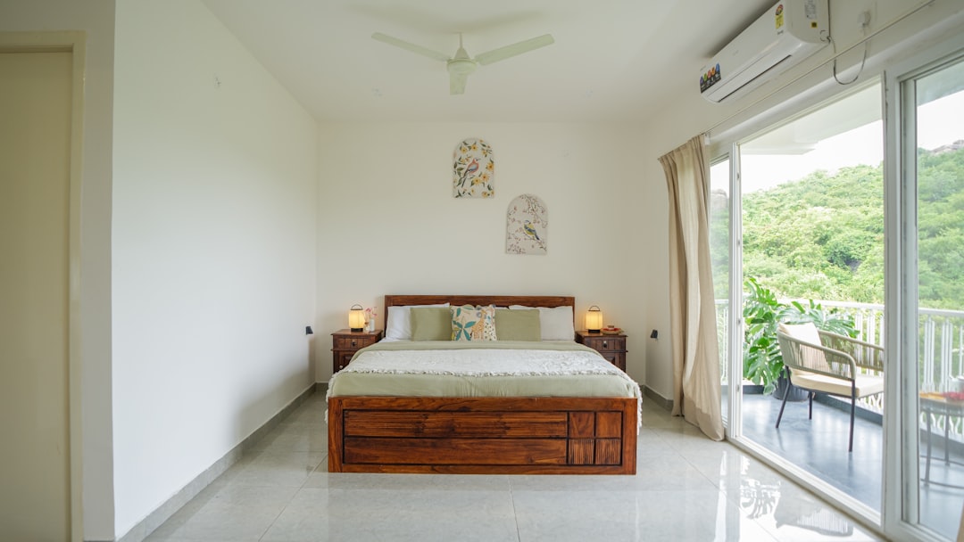 Dormitorio de segunda residencia con balcón y vistas, ideal para climatizar con aire acondicionado