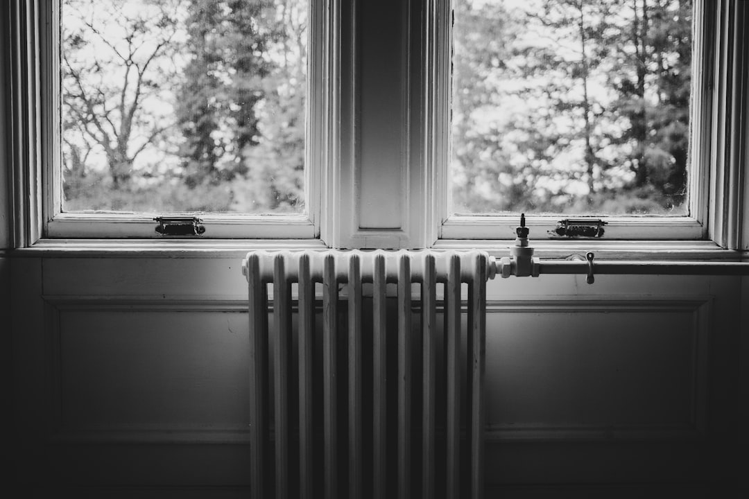 Radiador junto a una ventana representando sistemas de calefacción eléctrica para el hogar