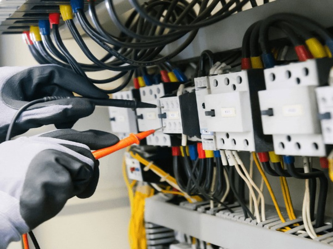Electricista comprobando cuadro eléctrico con multímetro para instalación de aire acondicionado