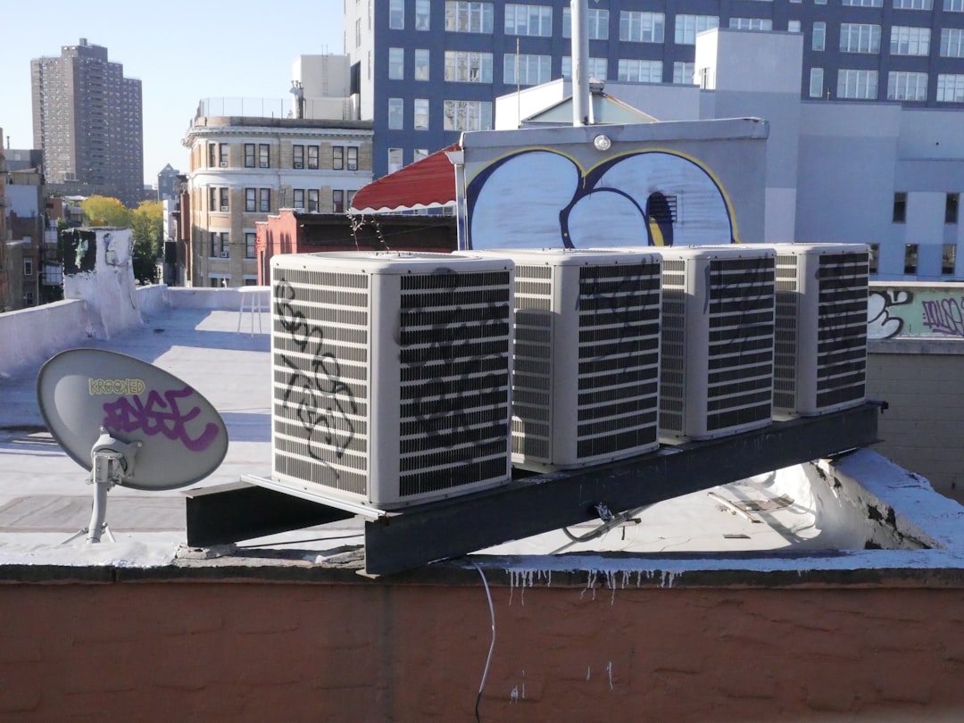 Tecnico revisando unidad exterior de aire acondicionado split antes del verano en una vivienda mediterranea