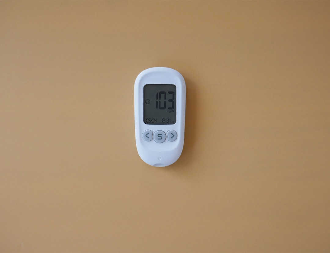 Termostato digital en pared indicando temperatura del aire acondicionado que echa aire caliente
